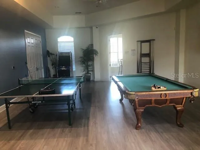 a room with pool table and windows