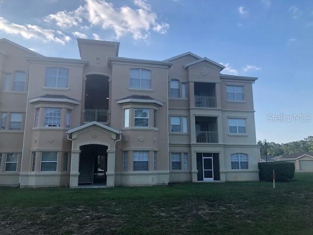 120 Terrace Ridge Circle, Unit 120 Davenport, FL 33896 - Photo 10 of 11 a view of a brick building next to a yard