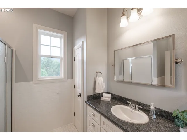 a bathroom with a granite countertop sink a mirror and a window