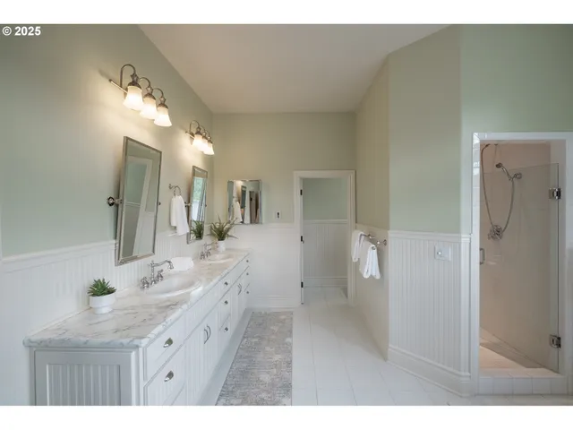 a bathroom with a double vanity sink and mirror with shower