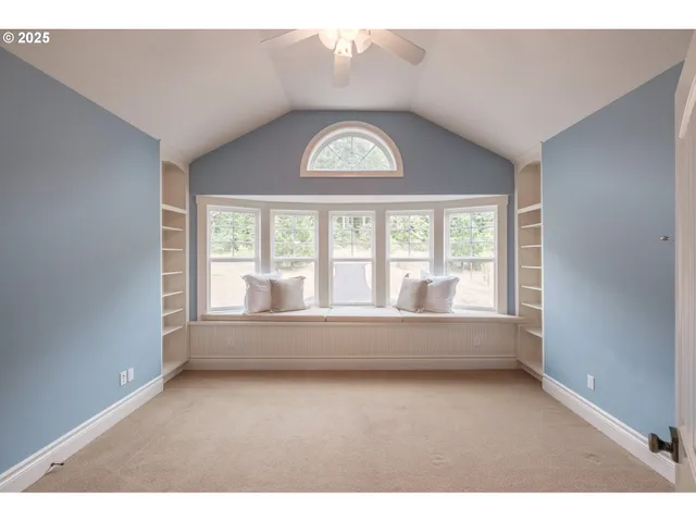 a view of an empty room with wooden floor and windows