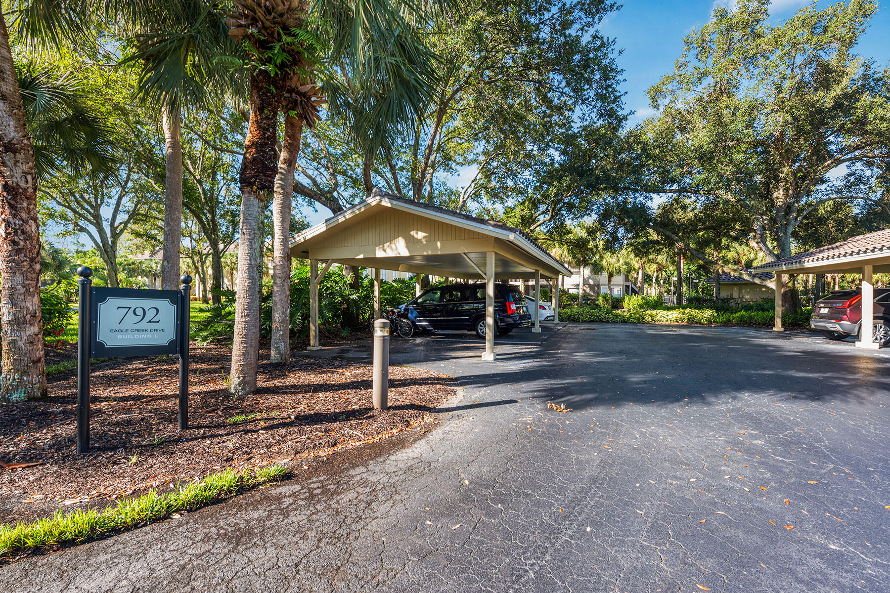 792 Eagle Creek Drive, Unit 204 Naples, FL 34113 - Photo 23 of 49 a street view with a bench and trees
