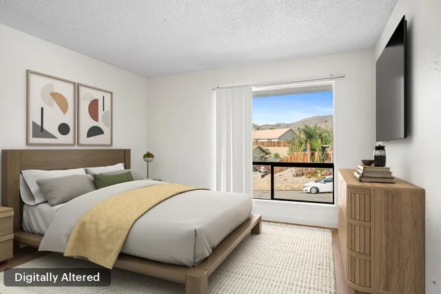 a bedroom with a bed and a flat tv screen on the dresser