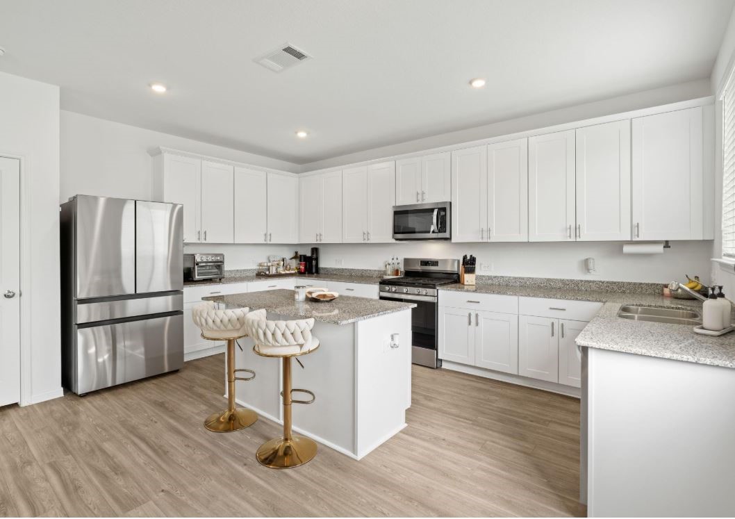 23543 Powmill Street Spring, TX 77373 - Photo 3 of 11 a kitchen with a refrigerator a microwave a sink and cabinets