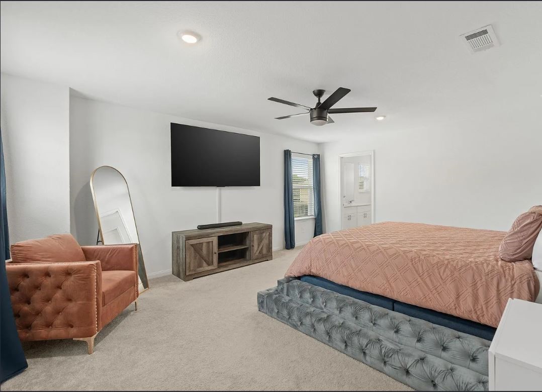 23543 Powmill Street Spring, TX 77373 - Photo 8 of 11 a spacious bedroom with a bed and a flat screen tv