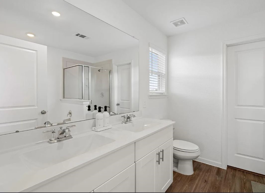 23543 Powmill Street Spring, TX 77373 - Photo 10 of 11 a bathroom with 2 sink toilet and a mirror