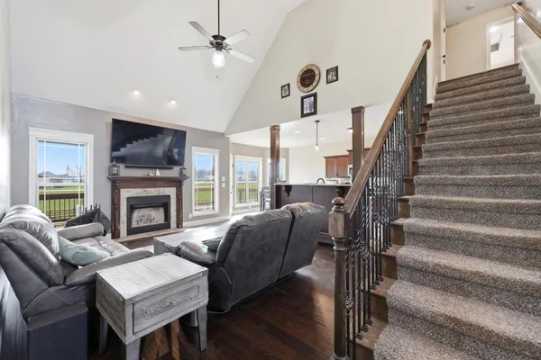 a living room with furniture a fireplace and a ceiling fan