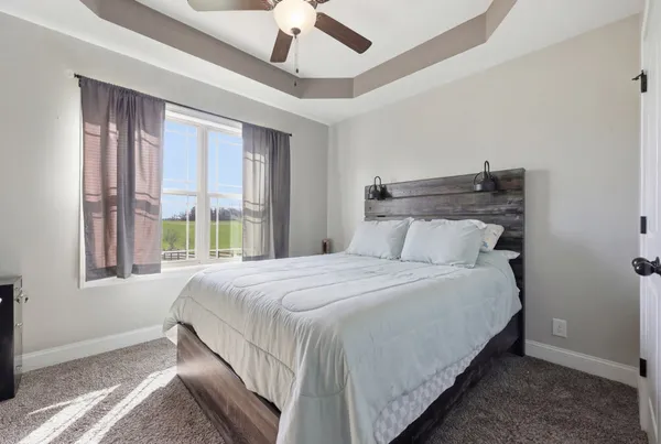 a bedroom with a bed and large windows