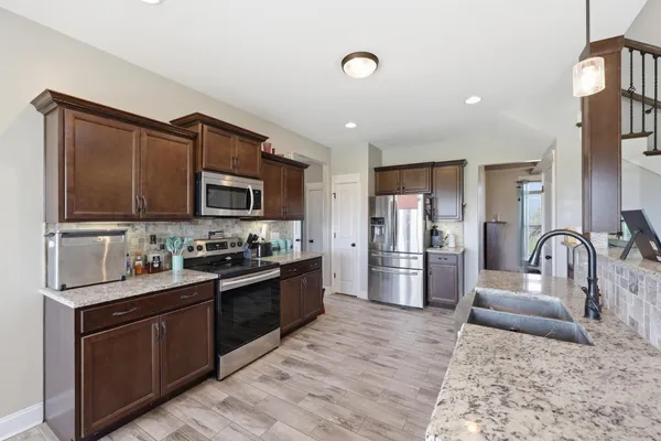 a kitchen with stainless steel appliances granite countertop a sink stove and refrigerator