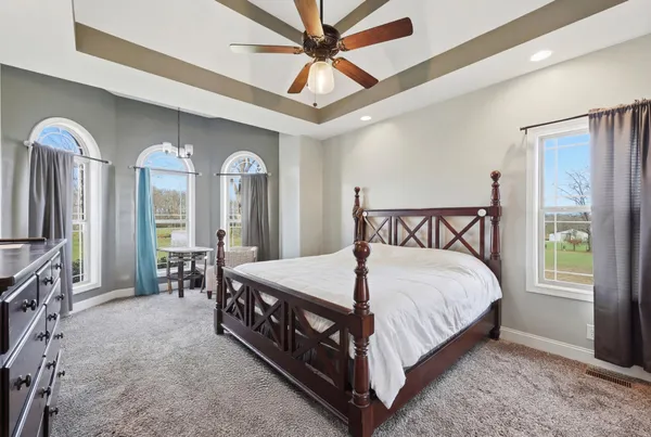a bedroom with a bed a chandelier and a dresser