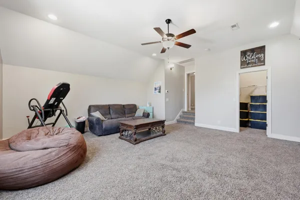 a living room with furniture and a ceiling fan