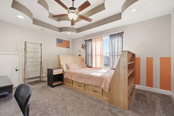 a spacious bedroom with a bed and a chandelier