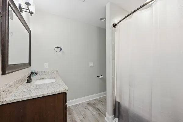 a bathroom with a granite countertop sink and a mirror