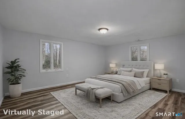 a bedroom with a large bed and a potted plant