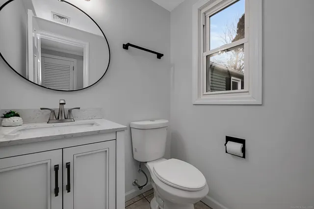 a bathroom with a toilet a sink and mirror