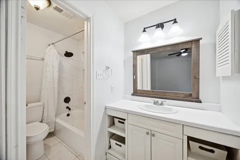 a bathroom with a sink a toilet a mirror and shower