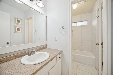 a bathroom with a granite countertop sink and a mirror