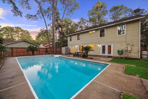 a view of a house with pool and a yard