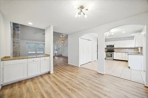 a large kitchen with stainless steel appliances kitchen island granite countertop a refrigerator and a sink