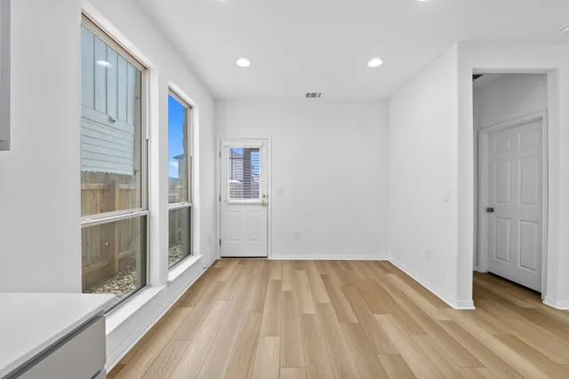 a view of hallway with a large window and wooden floor