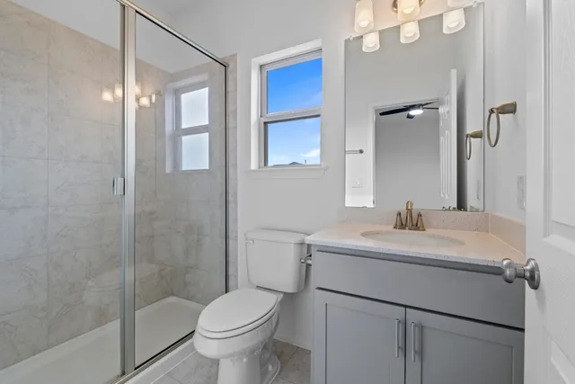 a bathroom with a sink toilet vanity and shower