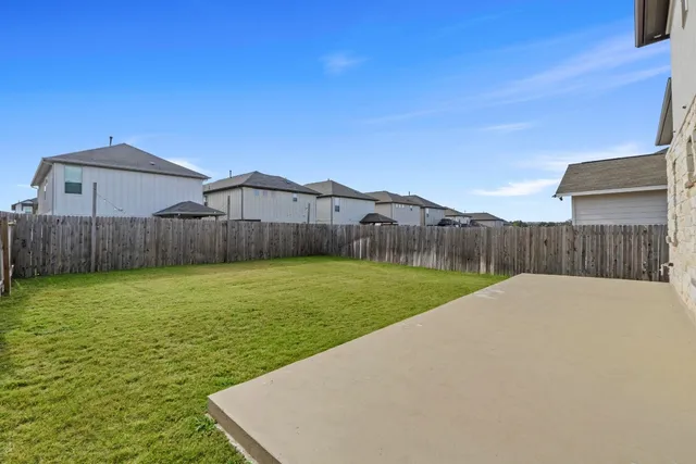 a view of a backyard with table and chairs with wooden fence