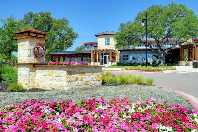 a front view of a house with a big yard and fountain