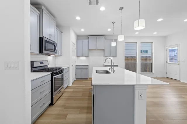a large kitchen with kitchen island a sink stainless steel appliances and cabinets