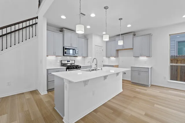 a kitchen with kitchen island a sink stainless steel appliances and cabinets