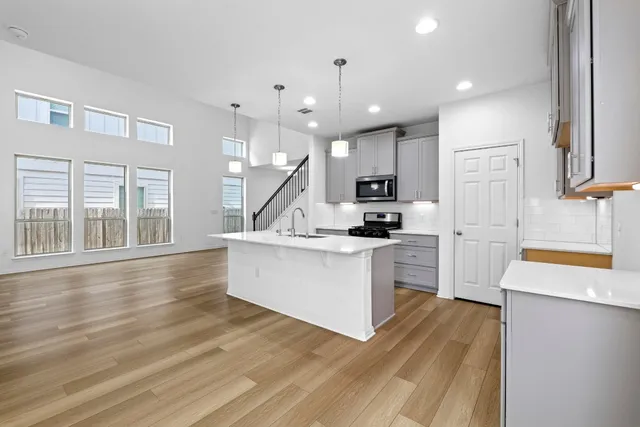 a kitchen with a refrigerator and a stove top oven