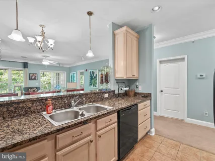 a kitchen with granite countertop stainless steel appliances a sink stove and cabinets