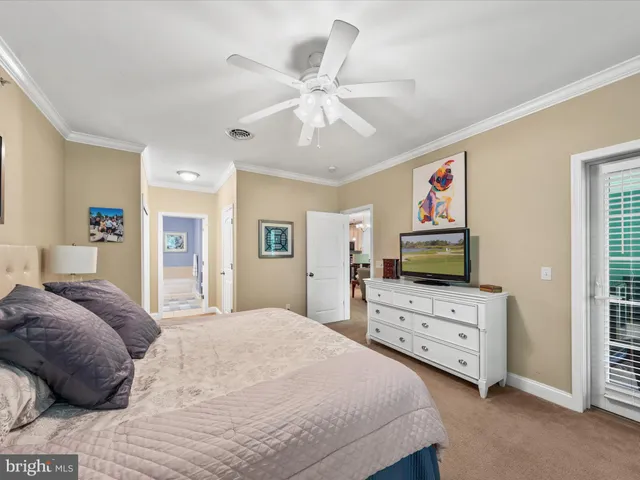 a bedroom with a bed and a flat tv screen on dresser