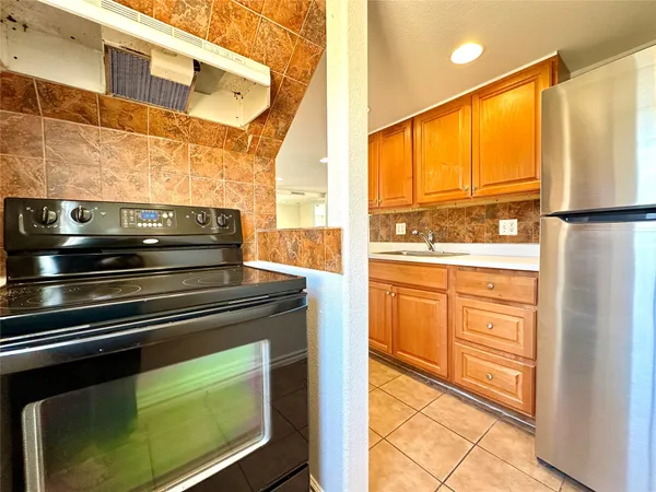 a kitchen with appliances cabinets and a large window