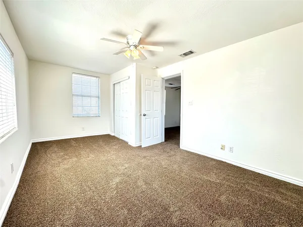 an empty room with a window and a fan