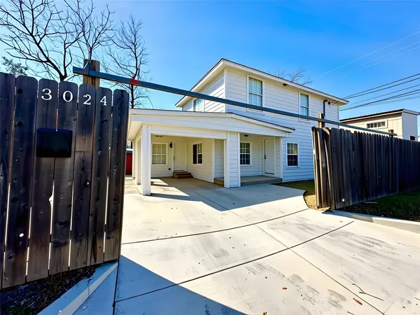a view of house with refrigerator and wooden fence