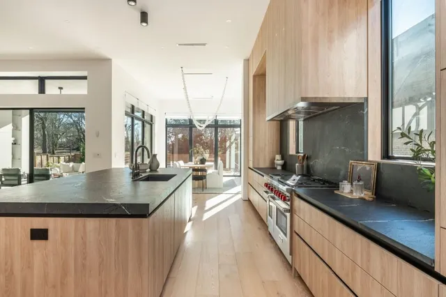 a kitchen with counter top space a sink and windows