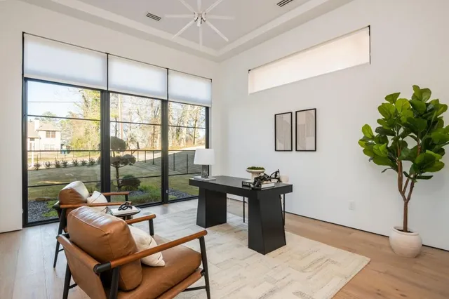 a living room with furniture a potted plant and a large window