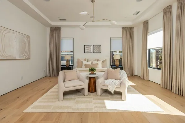 a living room with furniture a large window and wooden floor