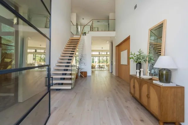 a view of a hallway with furniture and wooden floor