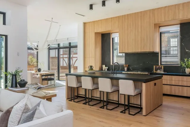 a living room with stainless steel appliances granite countertop a couch and cabinets