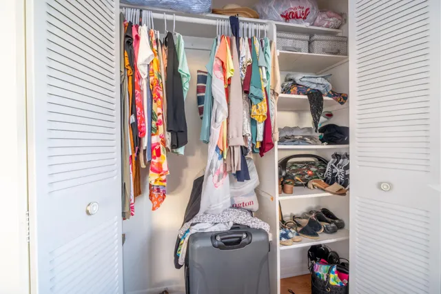 a view of walk in closet with clothes and shoes