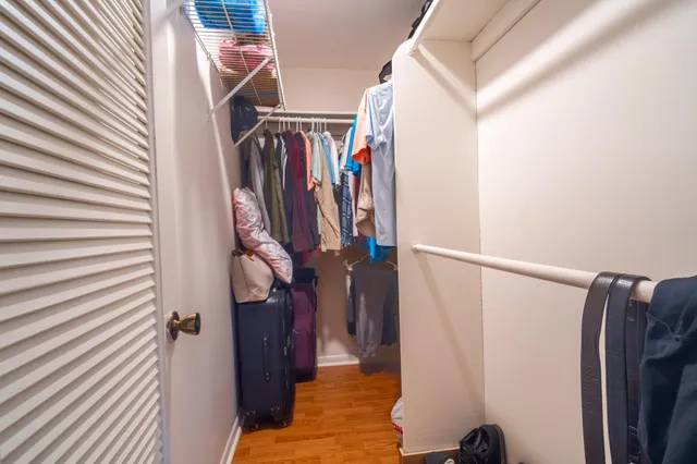 a view of walk in closet with clothes and shoes