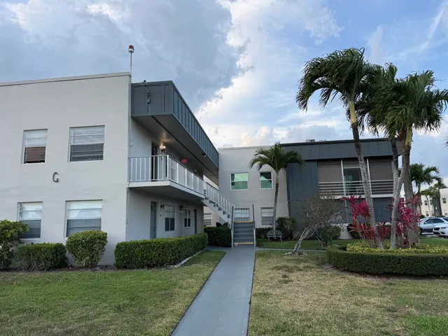 a front view of a house with a garden and plants