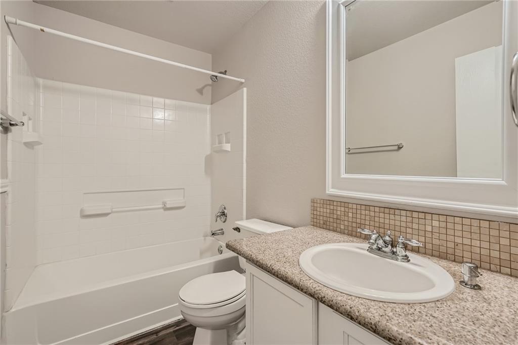 612 Copper Court Jarrell, TX 76537 - Photo 13 of 27 a bathroom with a granite countertop sink toilet and shower