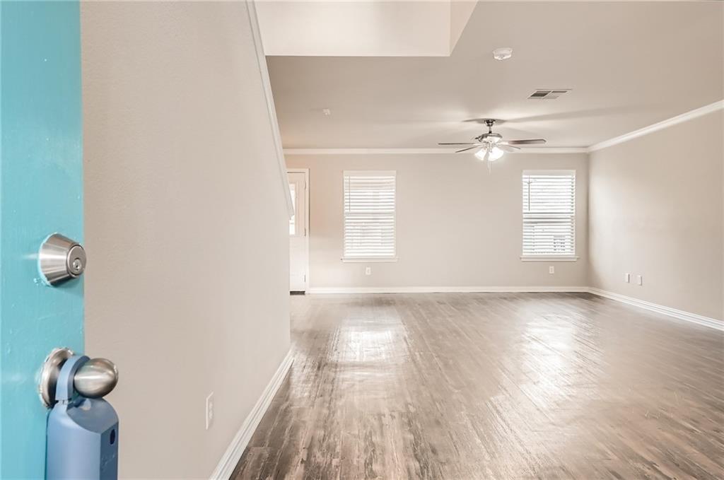 612 Copper Court Jarrell, TX 76537 - Photo 4 of 27 an empty room with wooden floor and windows