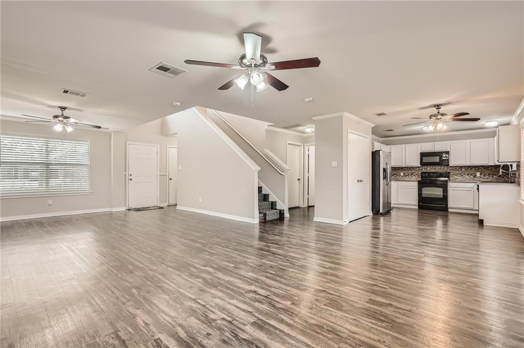 612 Copper Court Jarrell, TX 76537 - Photo 6 of 27 a view of empty room with wooden floor and kitchen view