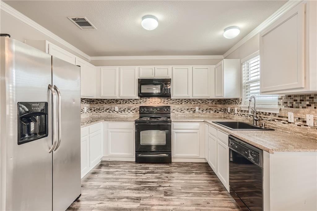 612 Copper Court Jarrell, TX 76537 - Photo 8 of 27 a kitchen with a refrigerator stove and microwave