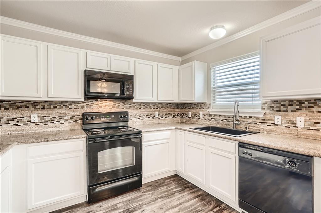 612 Copper Court Jarrell, TX 76537 - Photo 9 of 27 a kitchen with stainless steel appliances granite countertop a stove a sink and a microwave