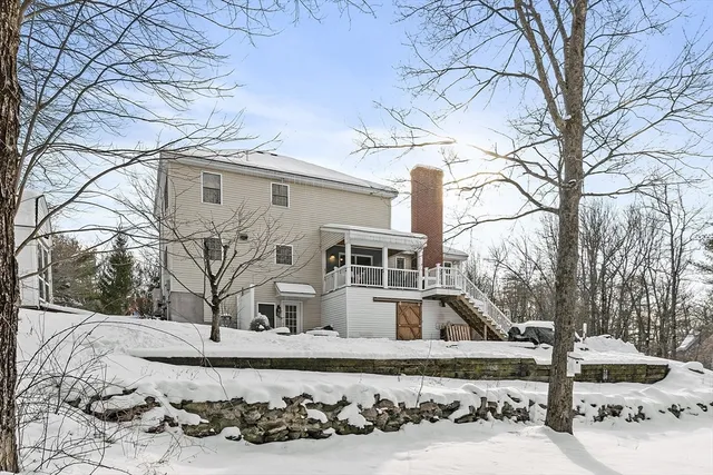 a view of a white house with a yard covered with snow in the backyard
