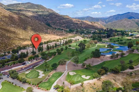 a view of a park with a building and mountains in the background